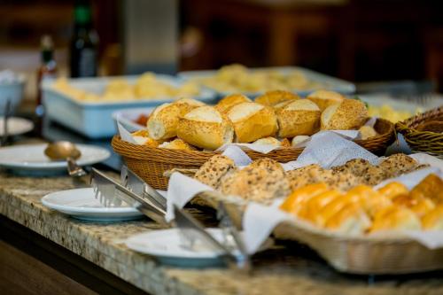 una mesa cubierta con cestas de pan y otros pasteles en Beach Hotel Juquehy, en Juquei