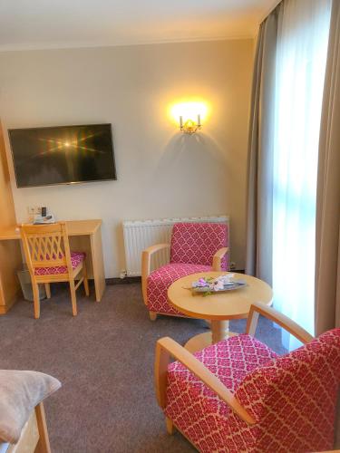a living room with a couch and a table and chairs at Andi's Skihotel in Obertauern