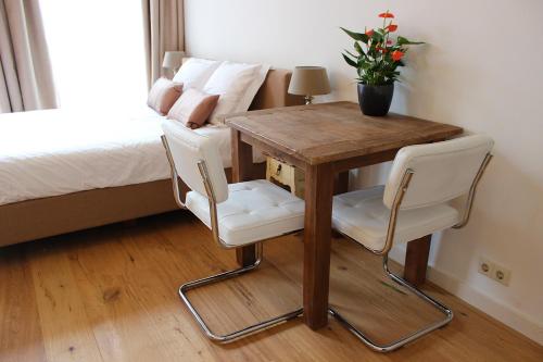 
a wooden table topped with a white chair next to a lamp at Amsterdam Jewel Canal Apartments in Amsterdam
