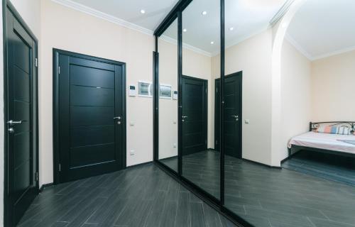 a bedroom with black doors and a bed and a mirror at 1к Люкс на Жилянская 118 in Kyiv