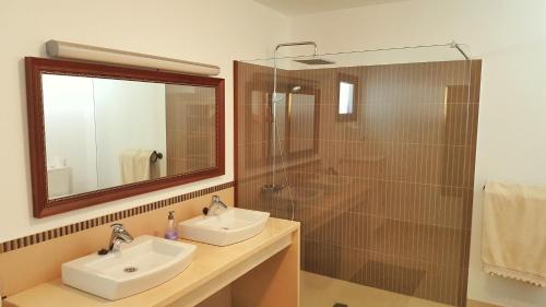 y baño con lavabo y ducha con espejo. en Villa Nazoly en Nazaret