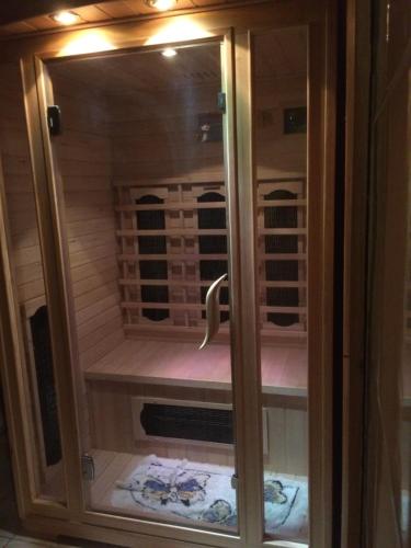 a shower with a glass door in a sauna at Bella Badacsony Apartmanház in Badacsonytomaj