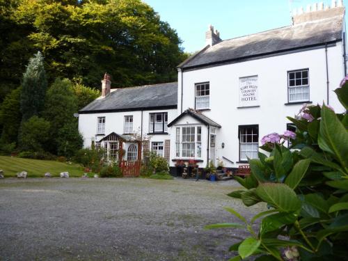 a white house with a yard in front of it at Score Valley Country House in Ilfracombe