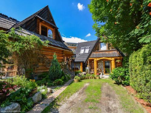 a log home with a pathway leading to the front yard at Figusówka in Zakopane