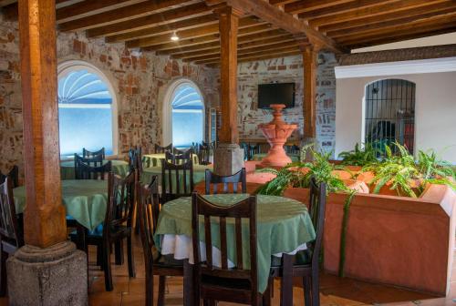 ein Esszimmer mit Tischen und Stühlen sowie einem TV in der Unterkunft Hotel Casa de las Fuentes in Antigua Guatemala