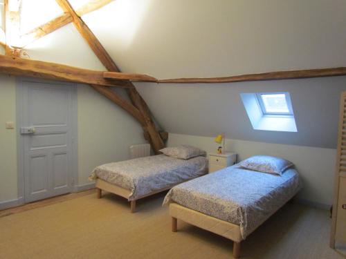 um quarto com 2 camas e uma clarabóia em Le Meix Gautheret em Merceuil