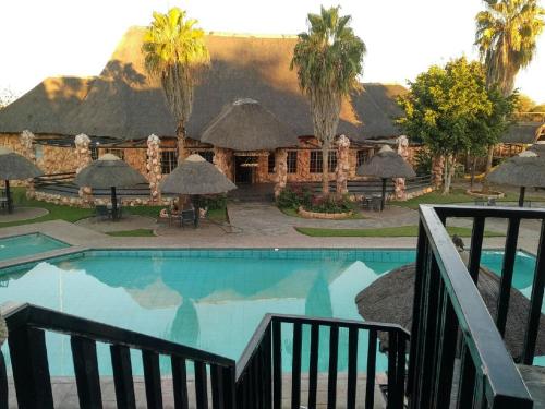 a resort swimming pool with a mountain in the background at The Big Five Lodge in Gaborone