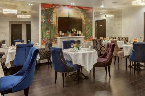 a dining room with tables and chairs and a fireplace at Seasons Boutique Hotel in Moscow