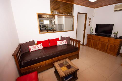 sala de estar con sofá y almohadas rojas en Departamento céntrico San Martín de los Andes en San Martín de los Andes