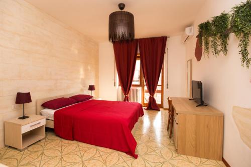 a bedroom with a red bed and a television at Quelli della via Gluck in Rome