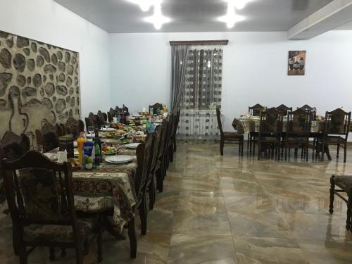 a dining room with tables and chairs and a table set with food at Christy Hotel in Goris