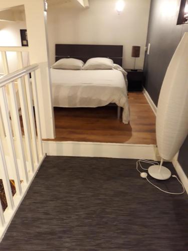 - une chambre avec un lit et un escalier avec une chaise dans l'établissement STUDIO INDEPENDENT, à Margaux
