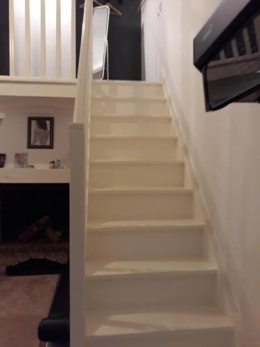 una escalera en una casa con escaleras blancas en STUDIO INDEPENDENT en Margaux