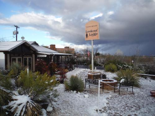 a sign in a garden with benches and a building at Landmark Lookout Lodge in Tombstone
