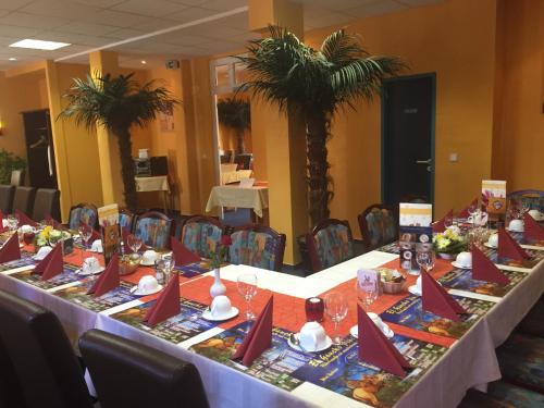 a long table with red napkins on it at Hotel Deutsches Haus Restaurant Olympia in Magdeburg