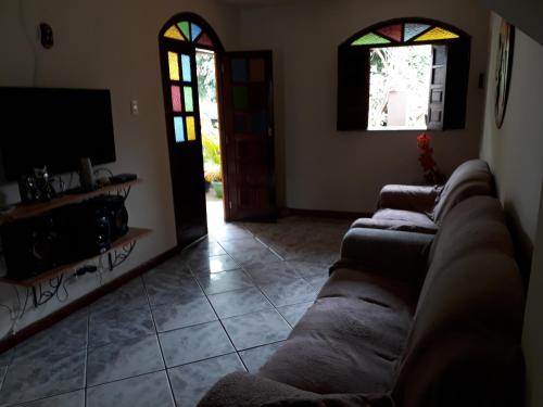 a living room with a couch and a tv at casa de Luciana - Lençóis in Lençóis