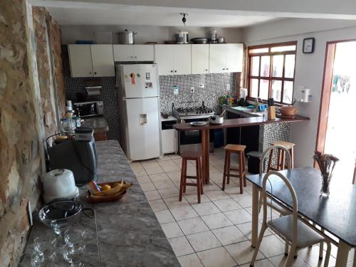 uma cozinha com um frigorífico, uma mesa e cadeiras em casa de Luciana - Lençóis em Lençóis