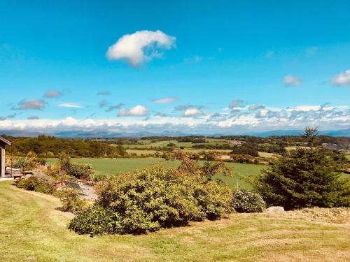 una vista de un campo con árboles y una casa en The Piggery - North Wales Retreat en Pwllheli