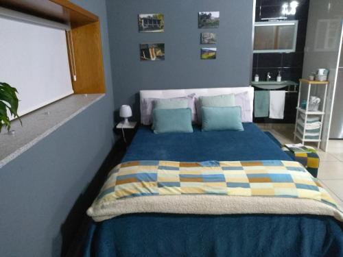 ein Schlafzimmer mit einem Bett mit einer blauen Decke und einem Fenster in der Unterkunft Canastro Country House in Castelo de Paiva