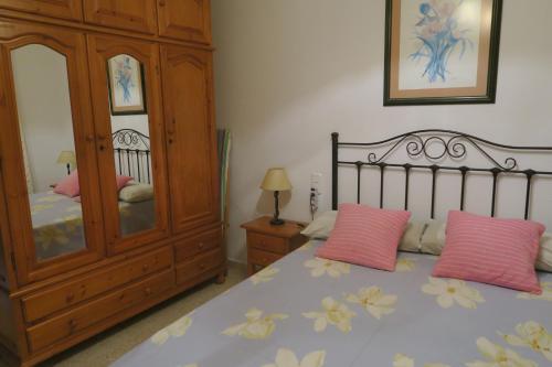 a bedroom with a bed with pink pillows and a cabinet at Balcon del mar in Morche