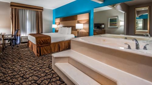 SeagovilleにあるBest Western Executive Innの大きなバスタブとベッドが備わるホテルルームです。
