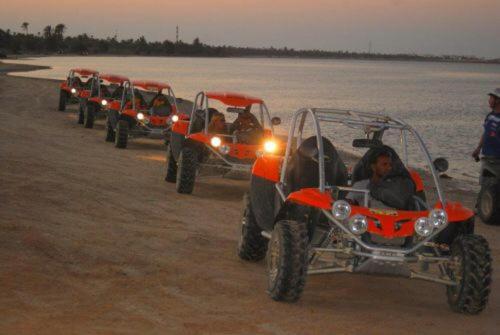 a row of four atvs parked on the beach at Appartement Touta écologique familial in Ḩawmat al Badawīyīn