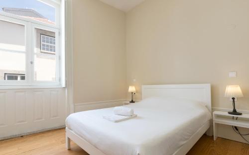 - une chambre blanche avec un lit blanc et une fenêtre dans l'établissement Best Guest Porto Hostel, à Porto