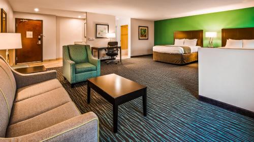 a hotel room with a bed and a couch and a table at Quality Inn & Suites in Burkburnett