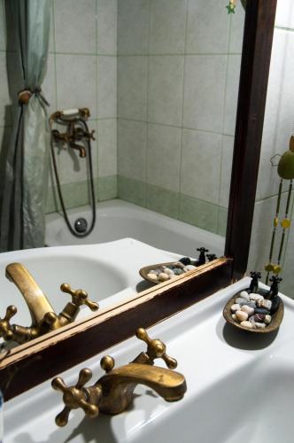a bathroom sink with a mirror and a bath tub at Aphrodite's Coast Retreat House! in Galaxidhion