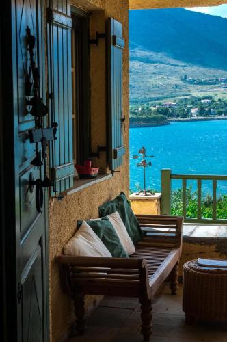 a porch with a bench and a view of the water at Aphrodite's Coast Retreat House! in Galaxidhion