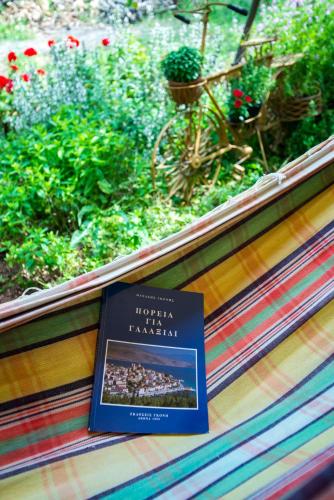 a book sitting on a bench next to a garden at Aphrodite's Coast Retreat House! in Galaxidhion