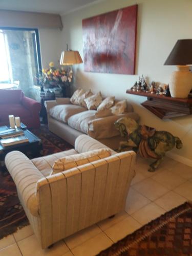 a living room with two couches and a couch at B&B Santo Domingo Chile ENGLISH SPOKEN Gran Departamento compartido frente al mar PARQUE TRICAO bird sanctuary 14kms 9miles away DESAYUNO ESTACIONAMIENTO Y WIFI GRATIS Free parking wifi and breakfast in Santo Domingo
