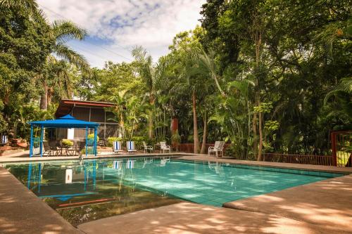 a swimming pool with a gazebo and trees at CASA CHU in Xochitepec