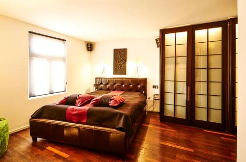 a bedroom with a large bed and a large window at Der Zauberlehrling in Stuttgart