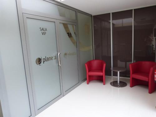 a room with two red chairs and a glass door at QUEST HOTEL - dawniej Hotel Planeta in Brzesko