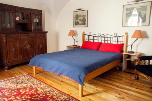 a bedroom with a bed with red pillows at Mieszkanie Old Town Apartment in Vilnius