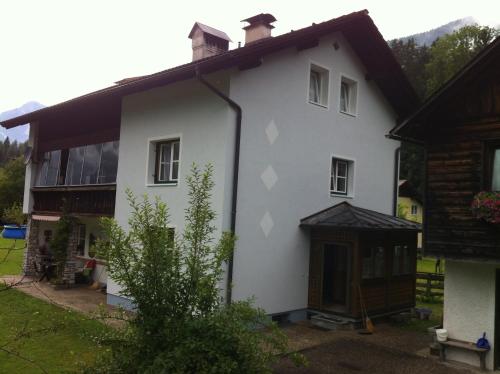 ein weißes Haus mit braunem Dach in der Unterkunft Ferienwohnung Stricker in Obertraun