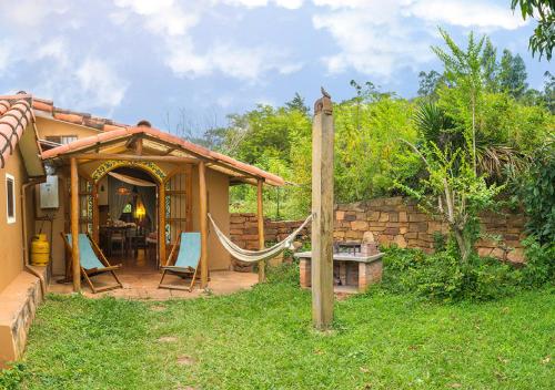 a patio with a hammock outside of a house at Finca La Vispera in Samaipata