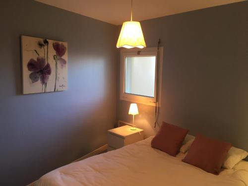 une chambre avec un lit avec une lampe et une fenêtre dans l'établissement Vistamar 2, à Merlimont