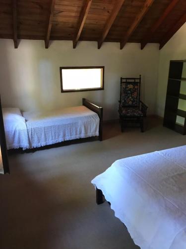 1 dormitorio con 2 camas y ventana a Casa verde en Mar de las Pampas
