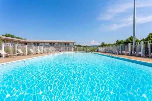 a large swimming pool with chairs in a building at Days Inn by Wyndham Breezewood in Breezewood