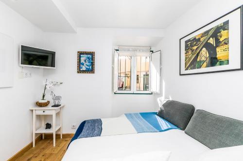 リスボンにあるLisbon Town Center Apartmentの白い部屋(ベッド2台、ソファ付)
