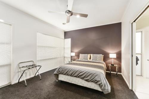 a bedroom with a bed and a black wall at Urban Corporate Apartment in Mount Gambier