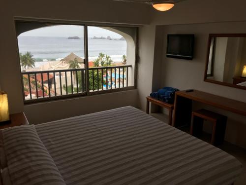 a bedroom with a bed and a view of the beach at Departamento 522 con playa dentro de Hotel en Ixtapa in Ixtapa