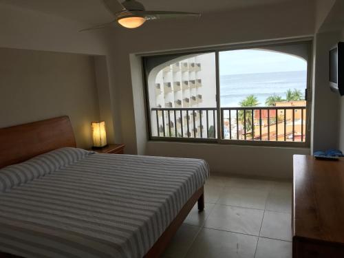 1 dormitorio con cama y vistas al océano en Departamento 522 con playa dentro de Hotel en Ixtapa, en Ixtapa