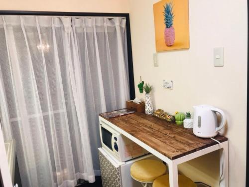 eine kleine Küche mit Tisch und Mikrowelle in der Unterkunft Mori de house in kobe 2 in Kōbe