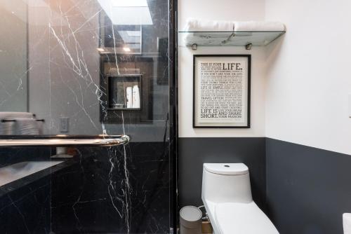 baño con aseo blanco y pared negra en Chic Pent House Polanco en Ciudad de México