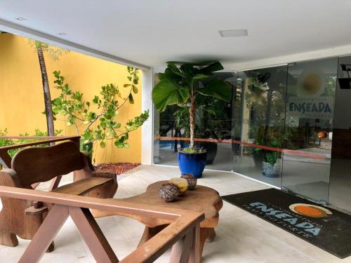 a chair and a table in a room with plants at Residencial Enseada Praia do Forte Apto 130 in Praia do Forte