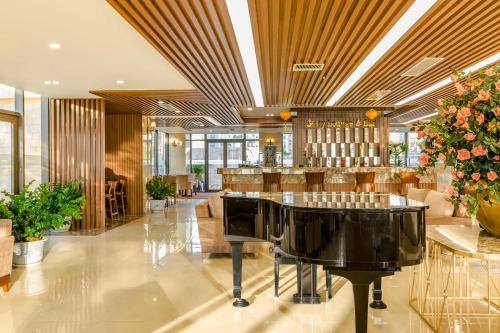 a restaurant with a piano in the middle of a lobby at Balcona Hotel Da Nang in Da Nang