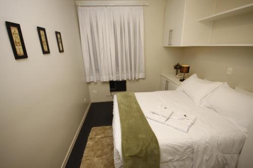 a bedroom with a white bed and a window at London Class Hotéis in Sao Paulo